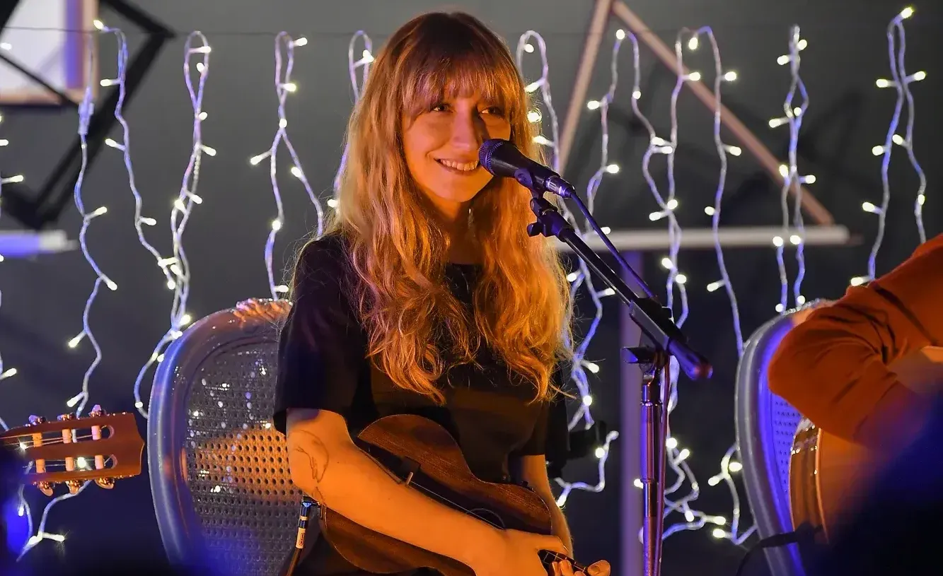Sahnede gitar çalan kadın müzisyenin performans anı.